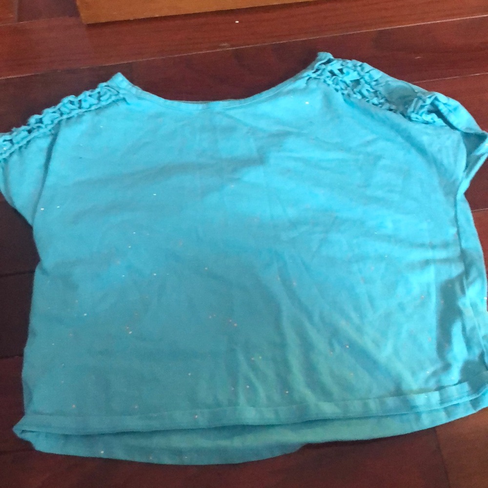 A blue glittery slightly cropped shirt